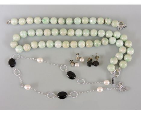 A single row uniform jade bead necklace and matching bracelet suite, an onyx and cultured freshwater pearl necklace, and two 