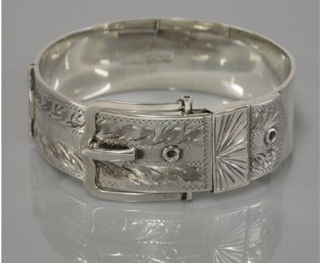 A silver bangle, in the form of a buckle