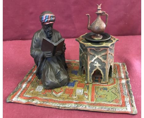 After Bergman, a cold painted figural desk inkwell depicting an Arabian man kneeling on a carpet. Table top is hinged, ink bo