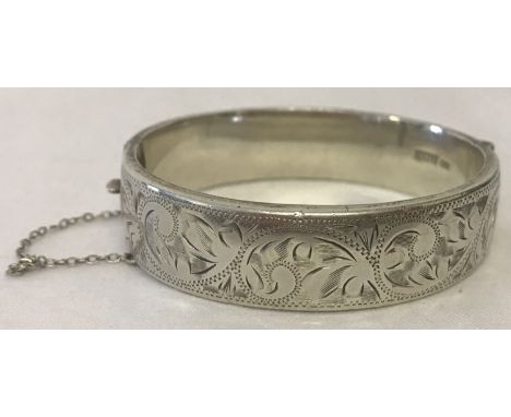 A vintage half floral engraved bangle complete with safety chain. Full hallmarks for Birmingham to inside of bangle. Total we