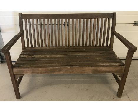 A 3 seater wooden garden bench with slat back detail.  