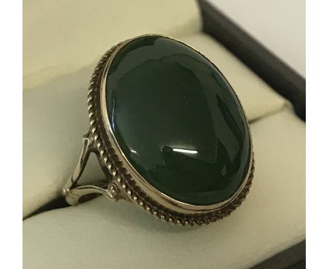 A 9ct gold dress ring set with an oval cut cabochon jade stone. Size N½. Total weight approx. 4g.