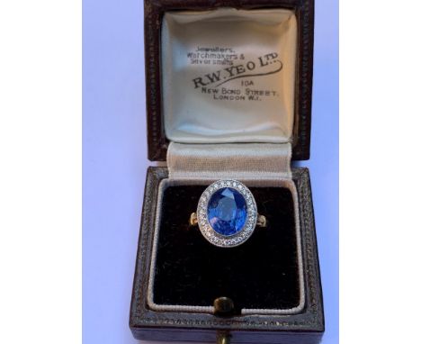 A certified natural 4.88 carat  Sri-Lankan sapphire &amp; diamond oval cluster ring, the white metal millegrain settings onto