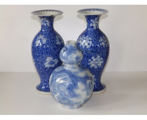 A pair of Chinese blue &amp; white porcelain vases of slender baluster form with flared rims, decorated overall with peonies 