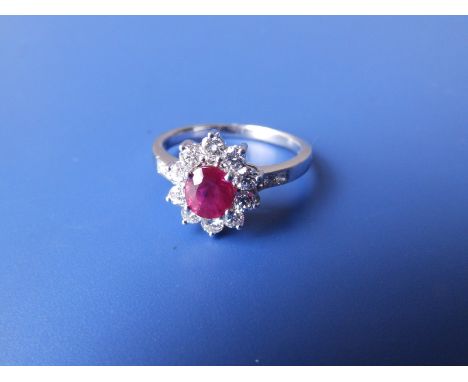 A modern oval ruby &amp; diamond cluster ring in 18k white metal.  Finger size Q/R.