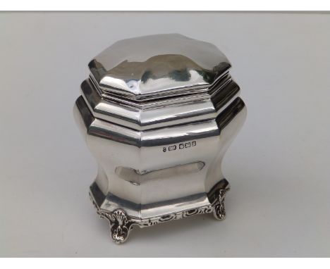 An octagonal silver tea caddy with hinged cover, on leaf cast feet - JK, Sheffield 1913,  4" high.