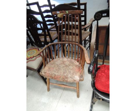 An early 19th century elm kitchen armchair, having comb spindle back with later cushion seat and splay turned legs, cushion i