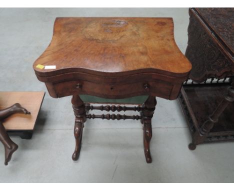 A Victorian burr walnut sewing/games table having swivel top over drawer and casket, on bulbous legs and bobbin stretchers, c