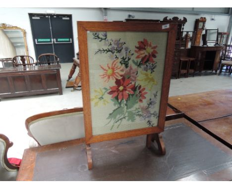 A 1930's golden oak frame firescreen/occasional table having woodwork inset, width approx. 46cm