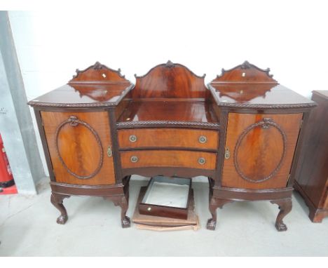 An early 20th century mahogany sideboard in the Chippendale revival style having crest and recess top with gadroon edge over 