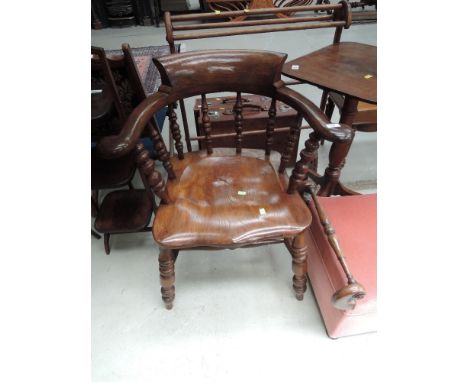 A late 19th/early 20th Century beech and elm captains chair having bobbin spindle back with scroll back and arms, solid seat 