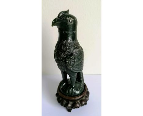 A 19th century carved Oriental jade bird of paradise, 14 cm H, on a pierced wooden stand 