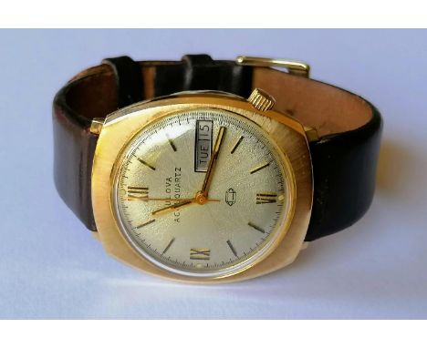 A 1976 Bulova Accuquartz gold cased day/date cushion-shape wristwatch, signed dial 34mm, stamped 10K, screw back, water resis