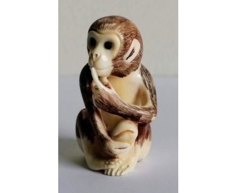 A Japanese netsuke in the form of a seated monkey, signed to base, 4.5 cm H 