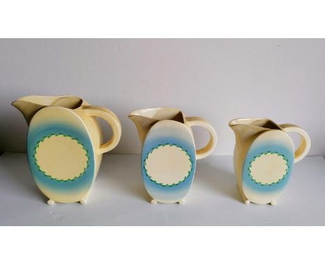 Three Clarice Cliff graduated water jugs, 15.5 to 19 cm H, regd. no. 776243, Wilkinson Ltd., in very good condition, minor ni