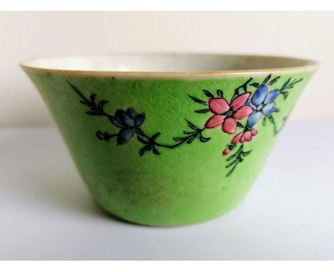 An 18th century Chinese green-ground bowl with incised dense floral scroll and painted enamel famille rose petals, 5.5 cm H x