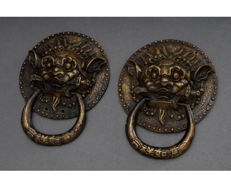 Paar chinesische Türklopfer "Fo-Löwen" mit Inschrift auf dem Ring, patinierte Bronze Nachgüsse, 19,5x15,5cm, kl. Defekte