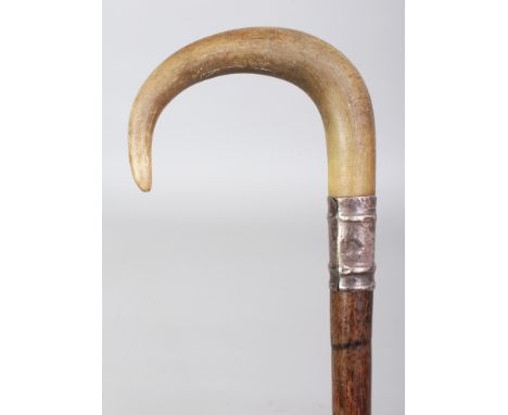 ANOTHER RHINO HORN HANDLED BAMBOO WALKING STICK, with an embossed and hallmarked silver collar, the curving rhinoceros horn h