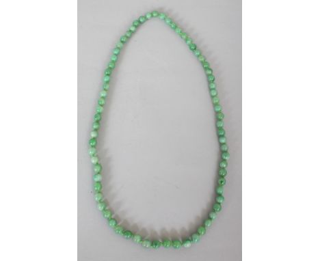 A CHINESE JADE-LIKE APPLE GREEN HARDSTONE NECKLACE, composed of spherical beads, approx. 29.5in long.