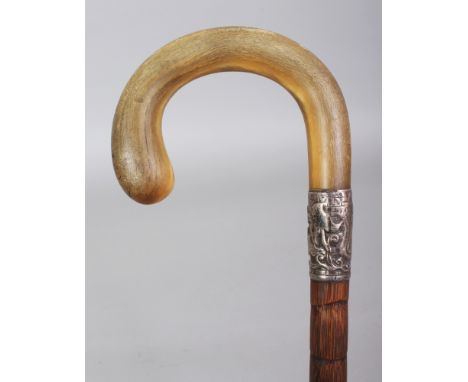 ANOTHER RHINO HORN HANDLED BAMBOO WALKING STICK, with an embossed silver-metal collar, the curving rhinoceros horn handle of 