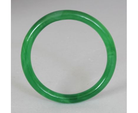 A CHINESE JADE-LIKE DARK GREEN GLASS BANGLE, 3.1in diameter, the inner rim 2.3in diameter.