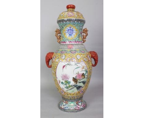 A LARGE CHINESE YELLOW GROUND FAMILLE ROSE PORCELAIN VASE & COVER, with moulded elephant-head handles, the sides decorated wi