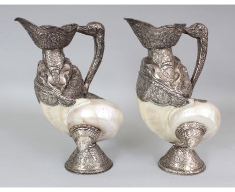 AN UNUSUAL PAIR OF TIBETAN SILVER-METAL MOUNTED NAUTILUS SHELLS, each shell with elaborately embossed silver metal fittings a