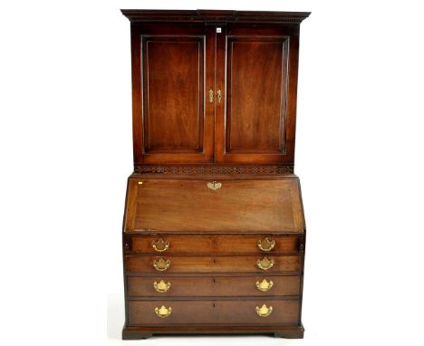 An early George III mahogany bureau bookcase, with breakfront dentil cornice above a pair of fielded panelled doors enclosing