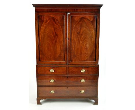 A George III gentleman's mahogany wardrobe, with a dentil cornice above a pair of crossbanded panelled doors enclosing hangin