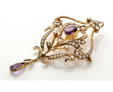 An Edwardian seed pearl and amethyst brooch/pendant, the central oval facet cut amethyst millegrain set within floral scroll 