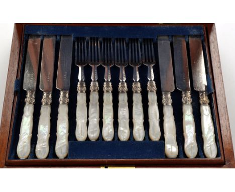 Twelve late Victorian fruit eating forks with knives to match, decorative ferrules and carved mother-of-pearl handles, in mah