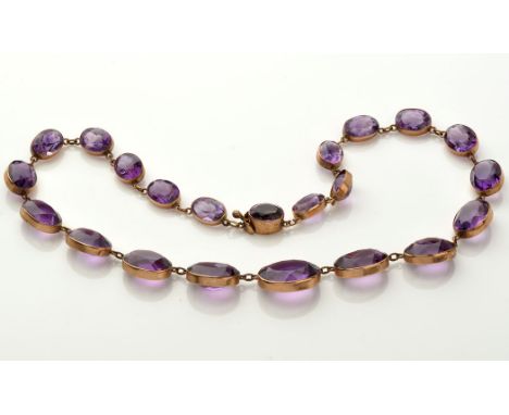 An amethyst necklace, set with twenty-two oval facet cut amethysts, each collet set in yellow metal, 33cms long.