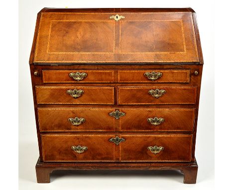 A fine George I walnut bureau, the top and rectangular fall-flap decorated with inlaid chevron banding, the flap with crossba