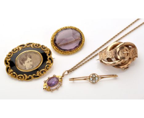 An early 20th Century amethyst, seed pearl and yellow metal pendant, the oval facet cut amethyst claw set within floral mount