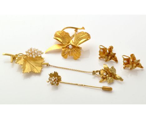 A suite of yellow metal jewellery set with seed pearls, to include: flower pattern brooch, matching pendant and earrings; a v