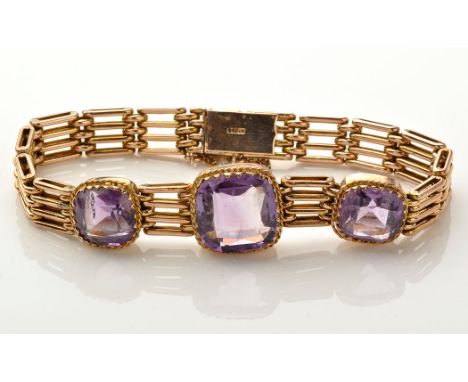 A 9ct. yellow gold and amethyst bracelet, the three graduated square mixed cut amethysts within a ropework bezel mount, on ga