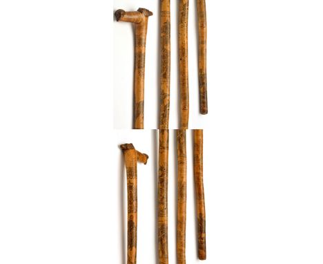 A Victorian pen and ink work decorated wooden walking-stick, the handle carved with a face and a bear pattern mask, engraved 