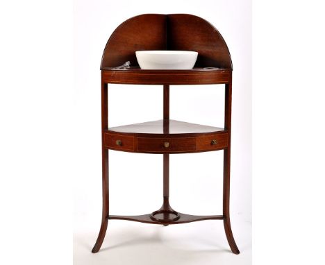A late Georgian mahogany corner wash stand, with raised back above basin and beaker apertures, complete with a pair of turned