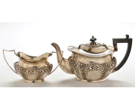 An Edwardian bachelor's teapot and matching sugar bowl, by William Henry Leather, Birmingham 1903, of embossed shaped oval fo