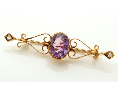 An Edwardian amethyst, diamond and yellow metal brooch, the oval facet cut amethyst claw set on a knife edge bar, on scrollin