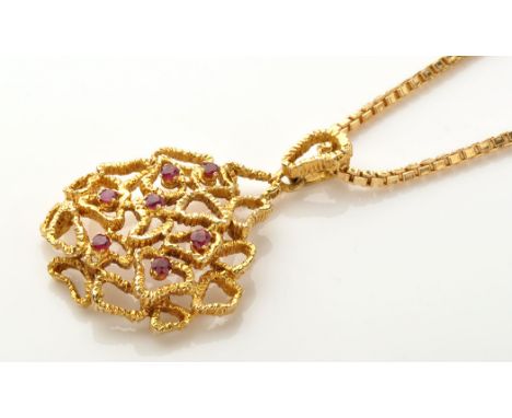A modern design 9ct. yellow gold and ruby set pendant, of shaped textured cells, set with seven circular facet cut rubies, on