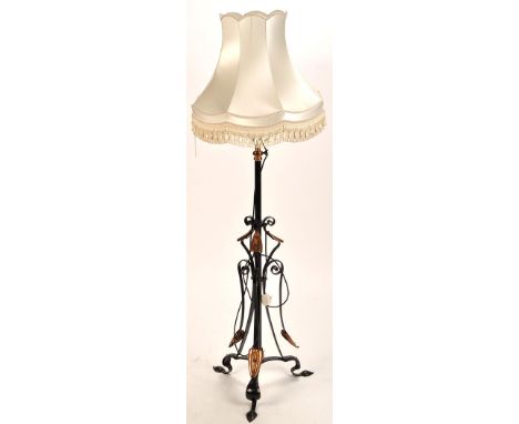 A wrought iron and copper Arts & Crafts design standard lamp, with brass oil lamp reservoir style fitting, above a copper mou