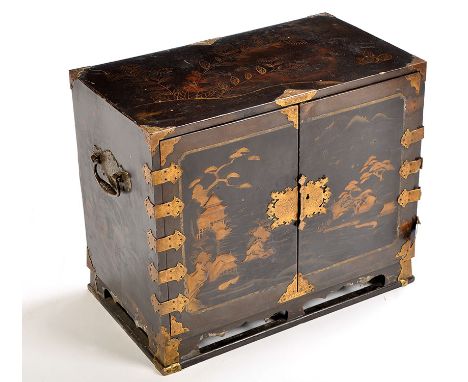 A Japanese Edo period (18th/19th Century) black lacquered brass-bound table cabinet, the pair of panelled doors decorated wit