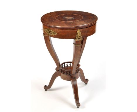 An early 19th Century North European circular mahogany work table, the hinged top with inlaid fan motif, opening to reveal a 