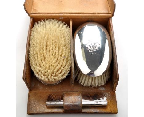 A pair of Edwardian silver backed brushes, by William Comyns, London 1907, oval and engraved monograms, crest and date; and a