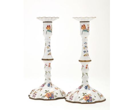 A pair of English Bilston enamel candlesticks, each with detachable drip pans, baluster stems and domed bases, painted polych
