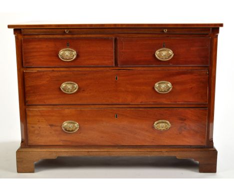 A late Georgian mahogany chest of two short and two long graduated drawers with embossed brass handles, fitted a later brushi