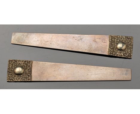 A pair of Elizabeth II silver and silver gilt paper knives/book marks, by Stuart Devlin, tapered with textured ends, 4in. (10