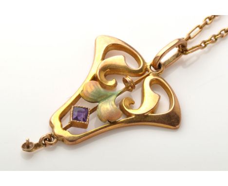 An Edwardian Art Nouveau pendant, set with facet cut amethyst in millegrain mount below enamel petals within yellow metal scr