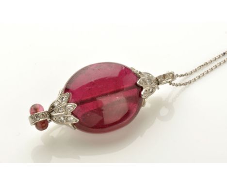 A ruby and diamond brooch/pendant, the oval polished ruby mounted at each end by floral cap set with eight-cut diamonds, furt